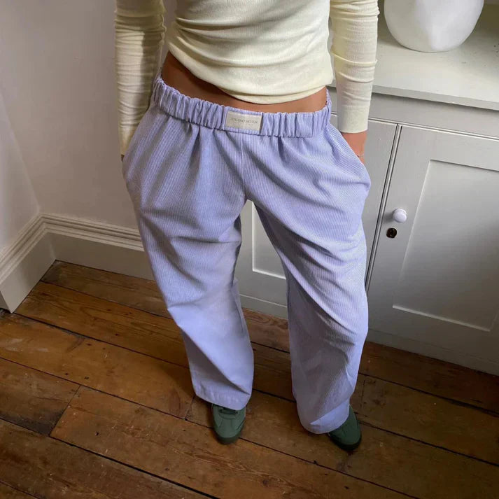 "Elegante hørbukser i åndbart stof, klassisk snit, i farver som gul og lilla for både formelle og afslappede lejligheder."