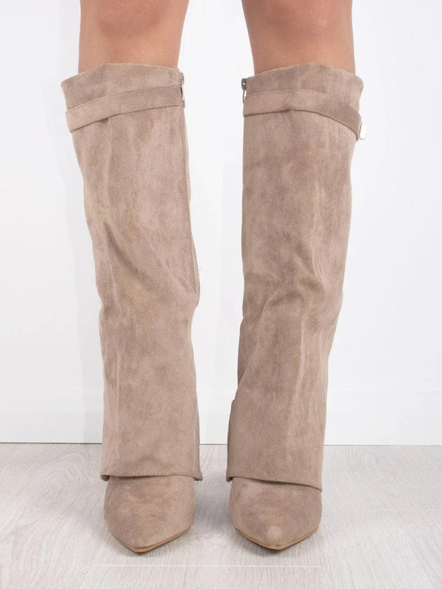 Kvindemodel iført elegante sorte lange støvler med blokhæl, fremhæver et stilfuldt efterårslook.