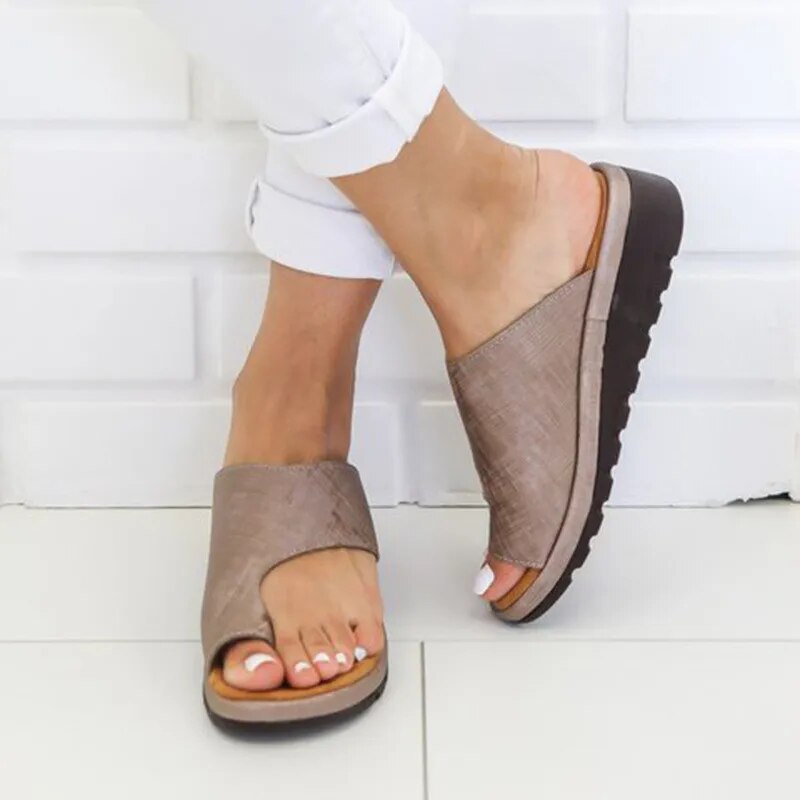 "Ergonomiske læder dame slippers i sort med justerbare stropper, designet til komfort og optimal støtte."