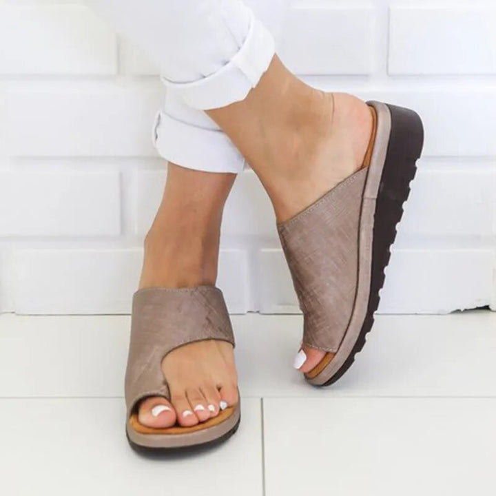 "Ergonomiske læder dame slippers i sort med justerbare stropper, designet til komfort og optimal støtte."