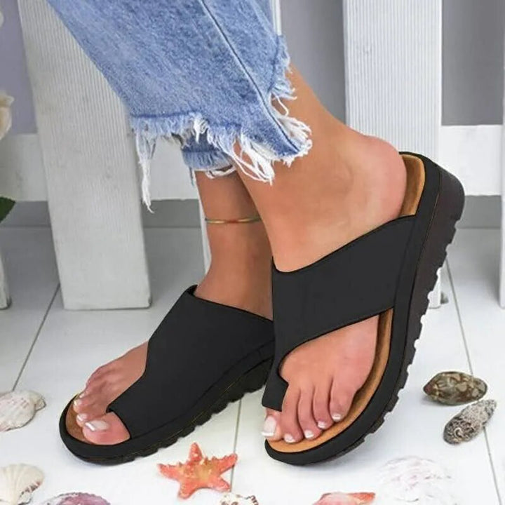 "Ergonomiske læder dame slippers i sort med justerbare stropper, designet til komfort og optimal støtte."