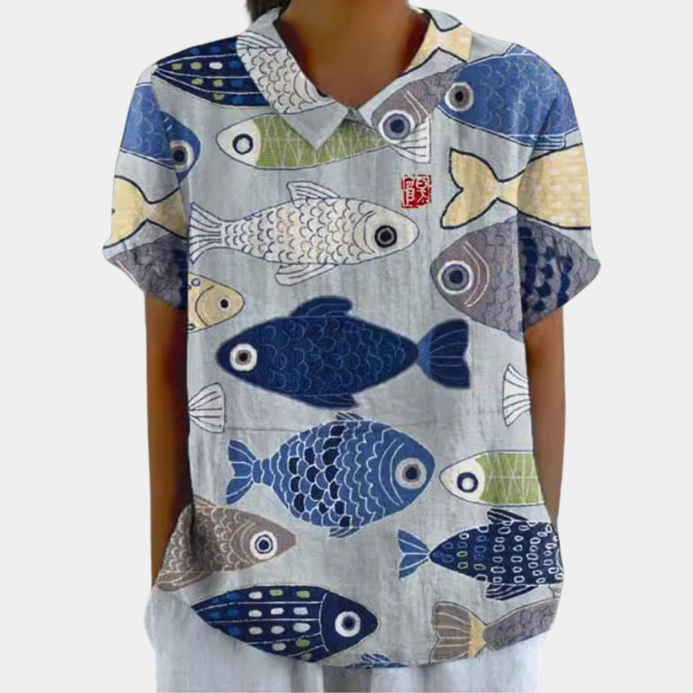 Levende damebluse med blomstermønster og rund krave, ideel til sommer. En stilfuld opgradering til enhver garderobe.