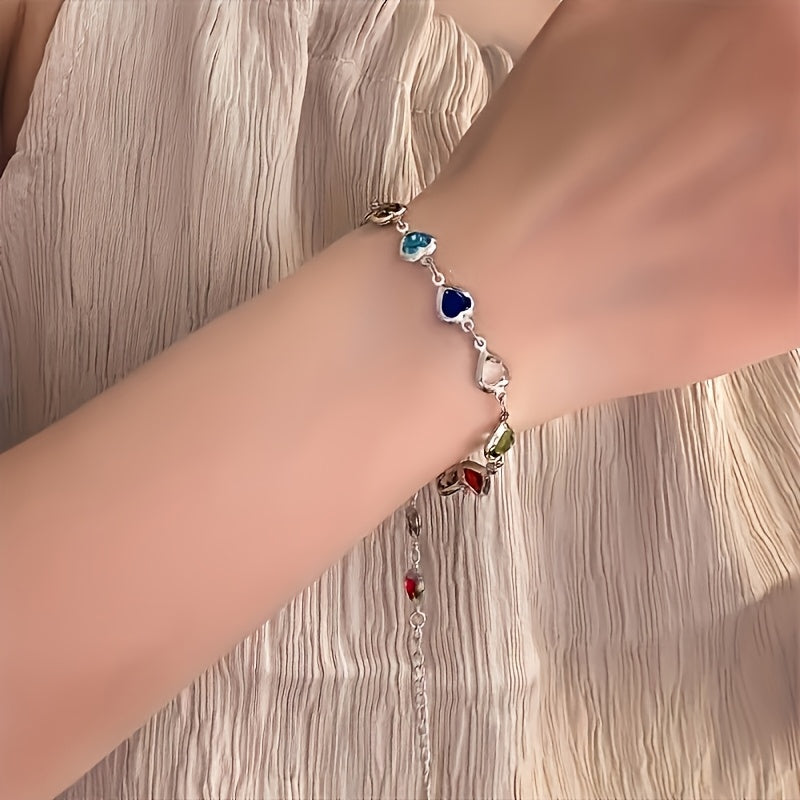 Romantisk guldfarvet armbånd med farverige krystalhjerter. Ideelt fest smykke eller hverdagssmykke.