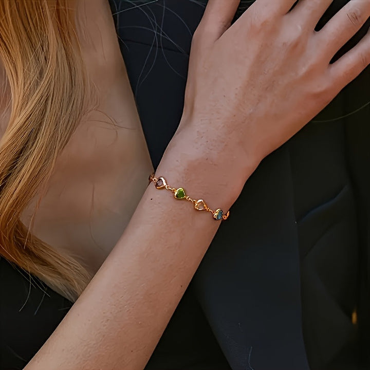 Kvalitets hjertearmbånd med glitrende farverige krystaller. Et elegant guldfarvet smykke til kvinder.
