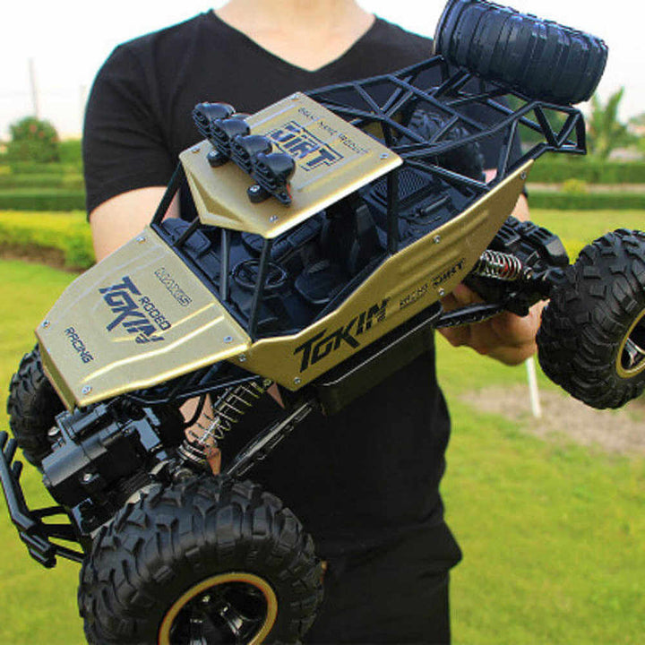 Et barn leger med en fjernstyret 4WD monster truck på en sti. Holdbar RC bil for udendørs leg.