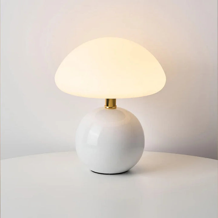 "Flødefarvet svampeinspireret bordlampe med Bauhaus-æstetik, cremefarvet skærm og elegant keramisk base."