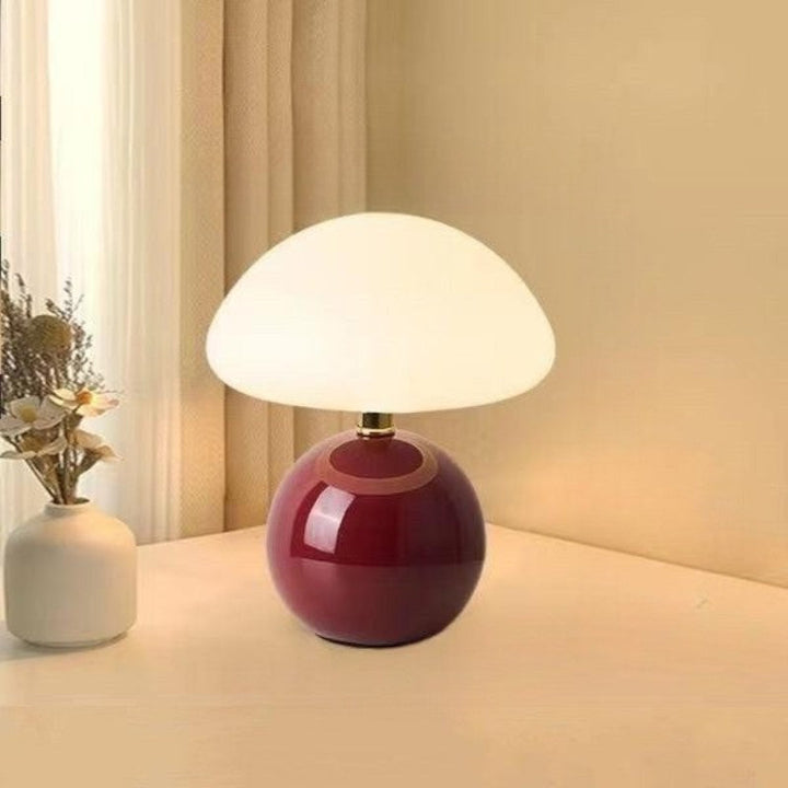 "Flødefarvet svampeinspireret bordlampe med Bauhaus-æstetik, cremefarvet skærm og elegant keramisk base."