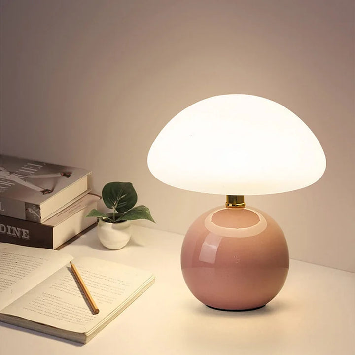 "Flødefarvet svampeinspireret bordlampe med Bauhaus-æstetik, cremefarvet skærm og elegant keramisk base."