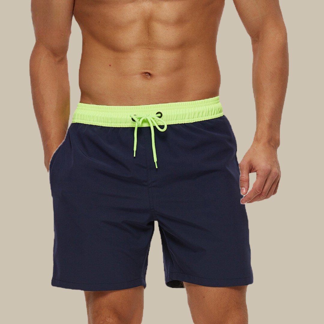 Hurtigtørrende herrebadeshorts med lynlåslommer og elastisk pasform, set forfra.