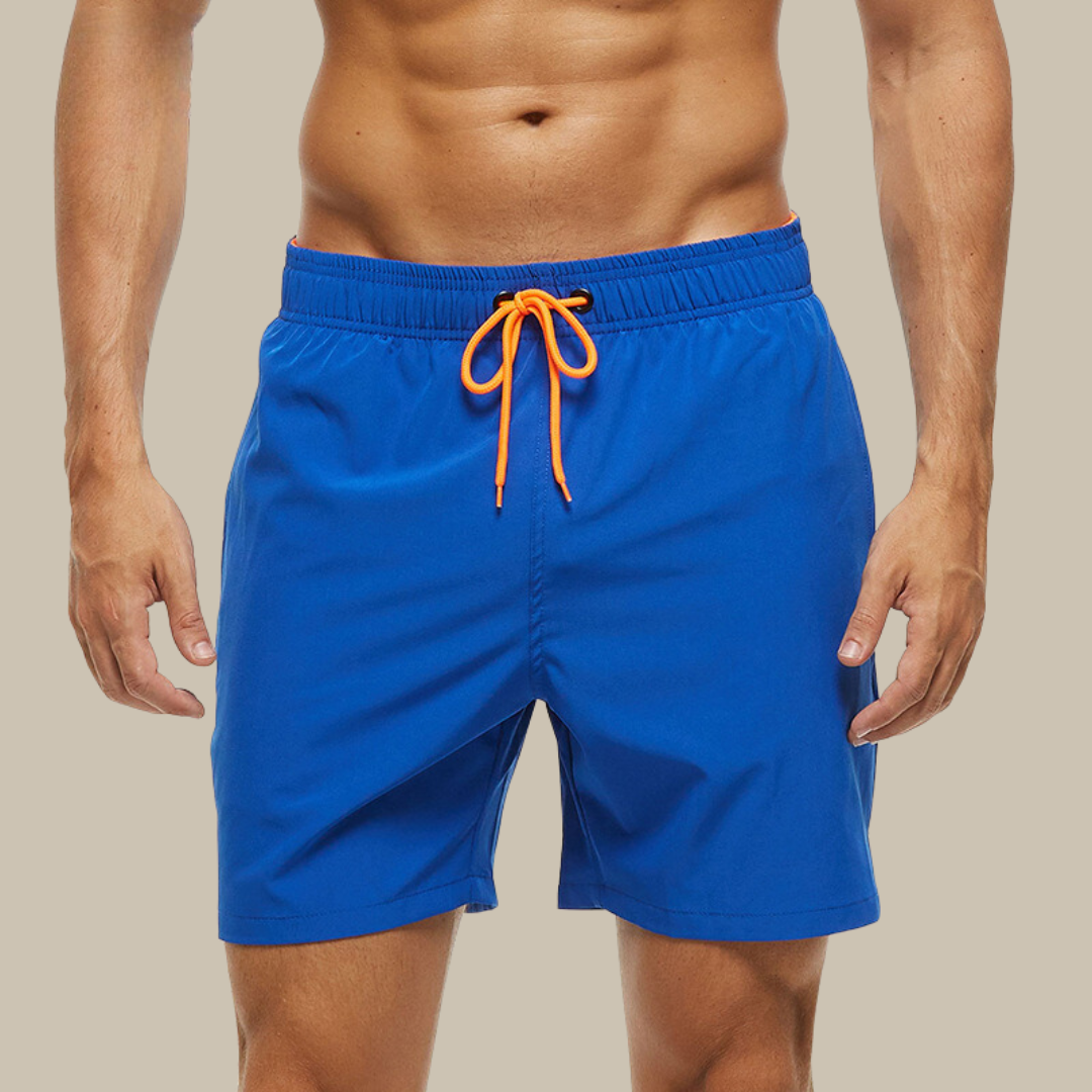 Hurtigtørrende herrebadeshorts med lynlåslommer og elastisk pasform, set forfra.