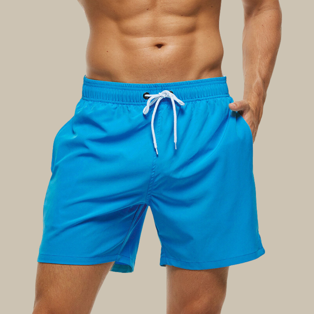 Hurtigtørrende herrebadeshorts med lynlåslommer og elastisk pasform, set forfra.