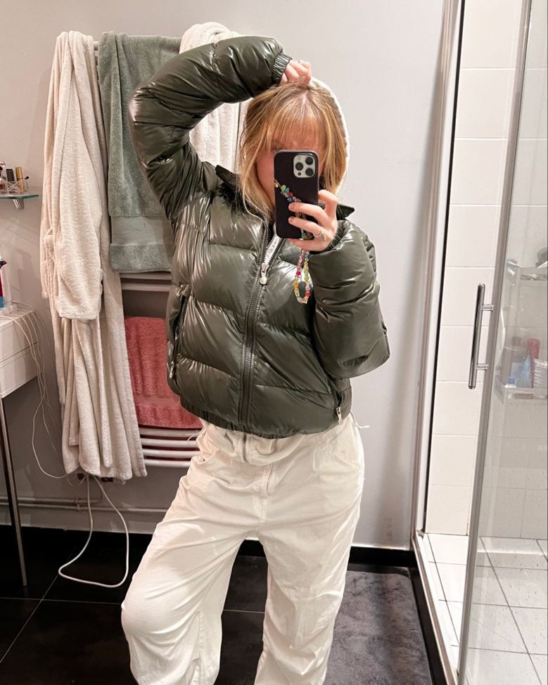 Model i kort, sort dame pufferjakke. Trendy hættejakke, varmt og letvægts overtøj til kvinder.