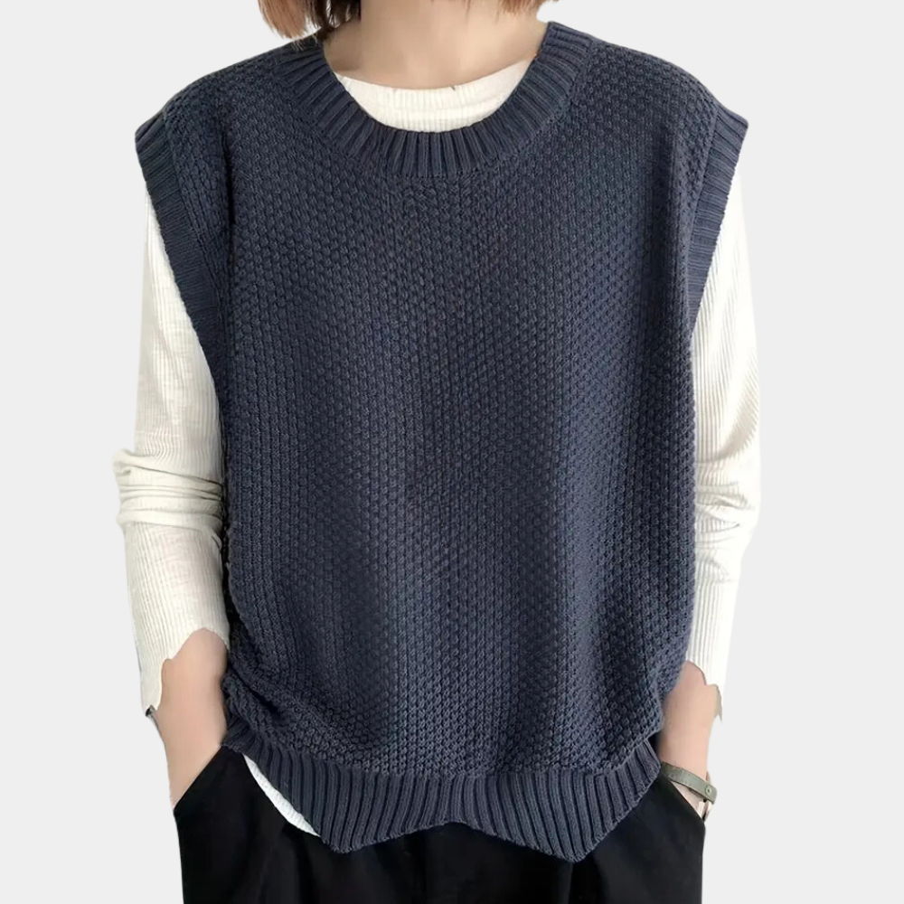 Kvinde i elegant strikket vest, løs pasform, marineblå, perfekt til forår og efterår.