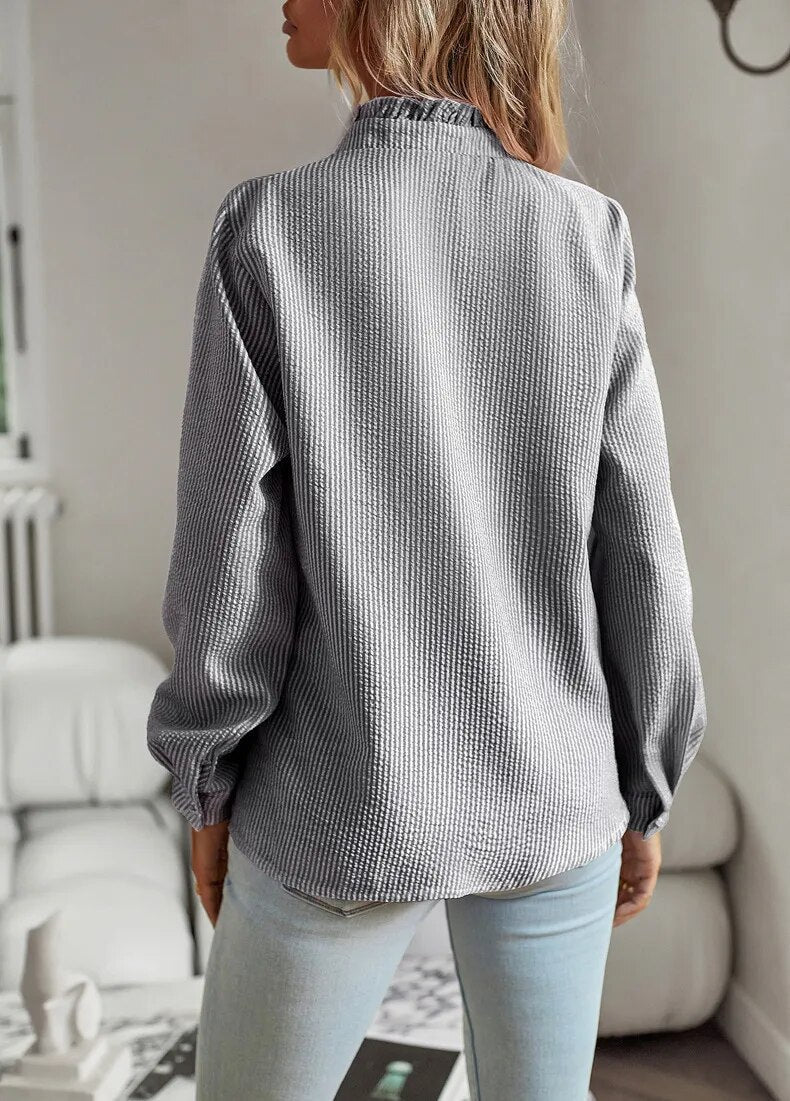 "Langærmet Chloë-bluse, flæsekant, mullet-design, flerfarvet mønster, unik og sofistikeret stil til kvinder."
