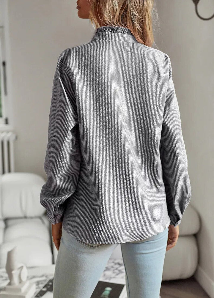 "Langærmet Chloë-bluse, flæsekant, mullet-design, flerfarvet mønster, unik og sofistikeret stil til kvinder."