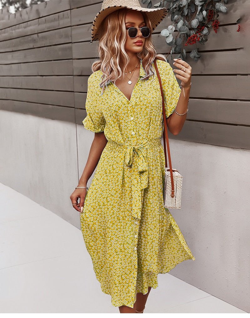 Bagside af elegant sommerkjole med blomsterprint. Midi-længde og bindebånd detalje.
