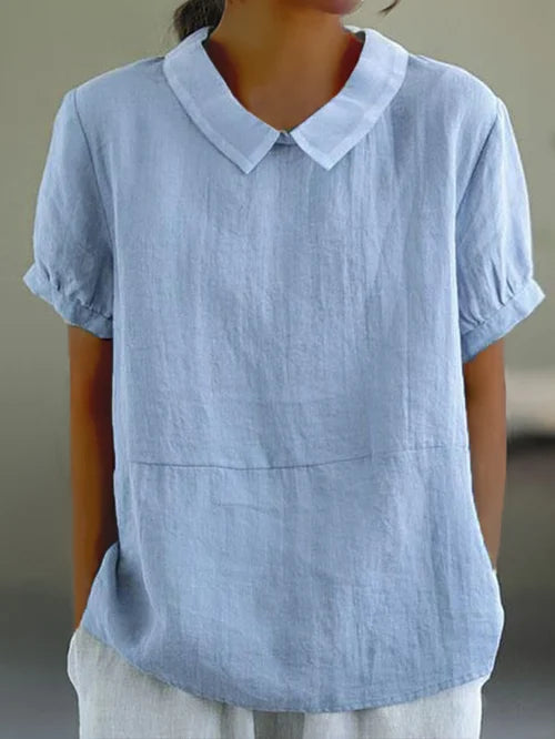 Elegant damebluse med Peter Pan krave, let design og perfekt til sommerdage, føles luftig.