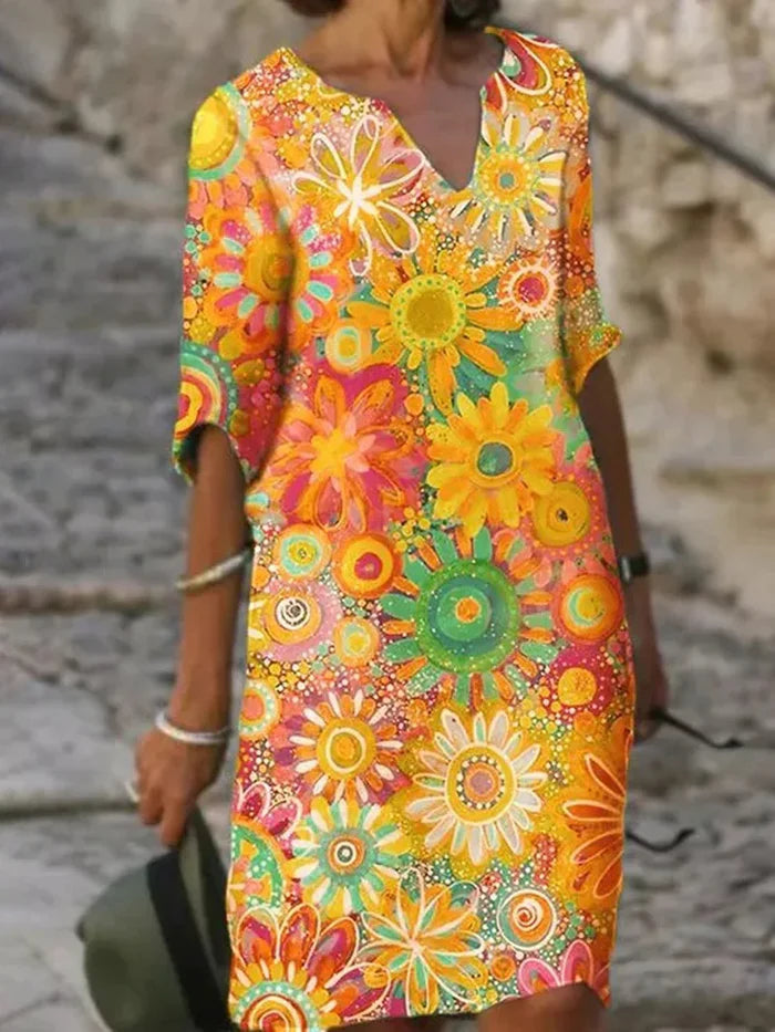 Dame sommerkjole med livligt blomsterprint, kort ærme og elegant V-hals, ideel til farveglade kvinder.