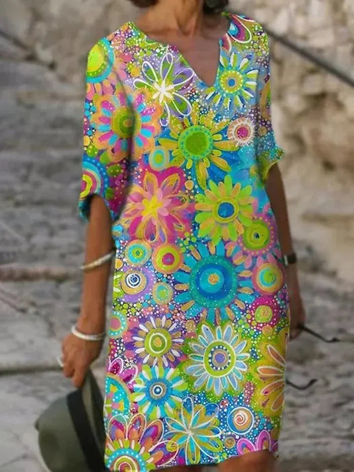 Dame sommerkjole med livligt blomsterprint, kort ærme og elegant V-hals, ideel til farveglade kvinder.