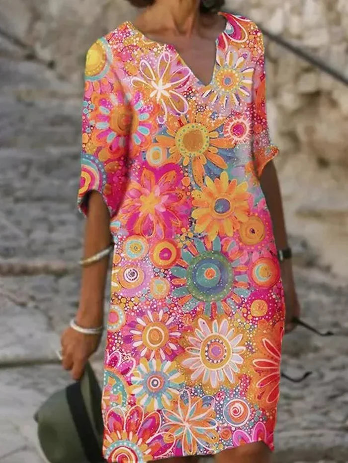 Dame sommerkjole med livligt blomsterprint, kort ærme og elegant V-hals, ideel til farveglade kvinder.