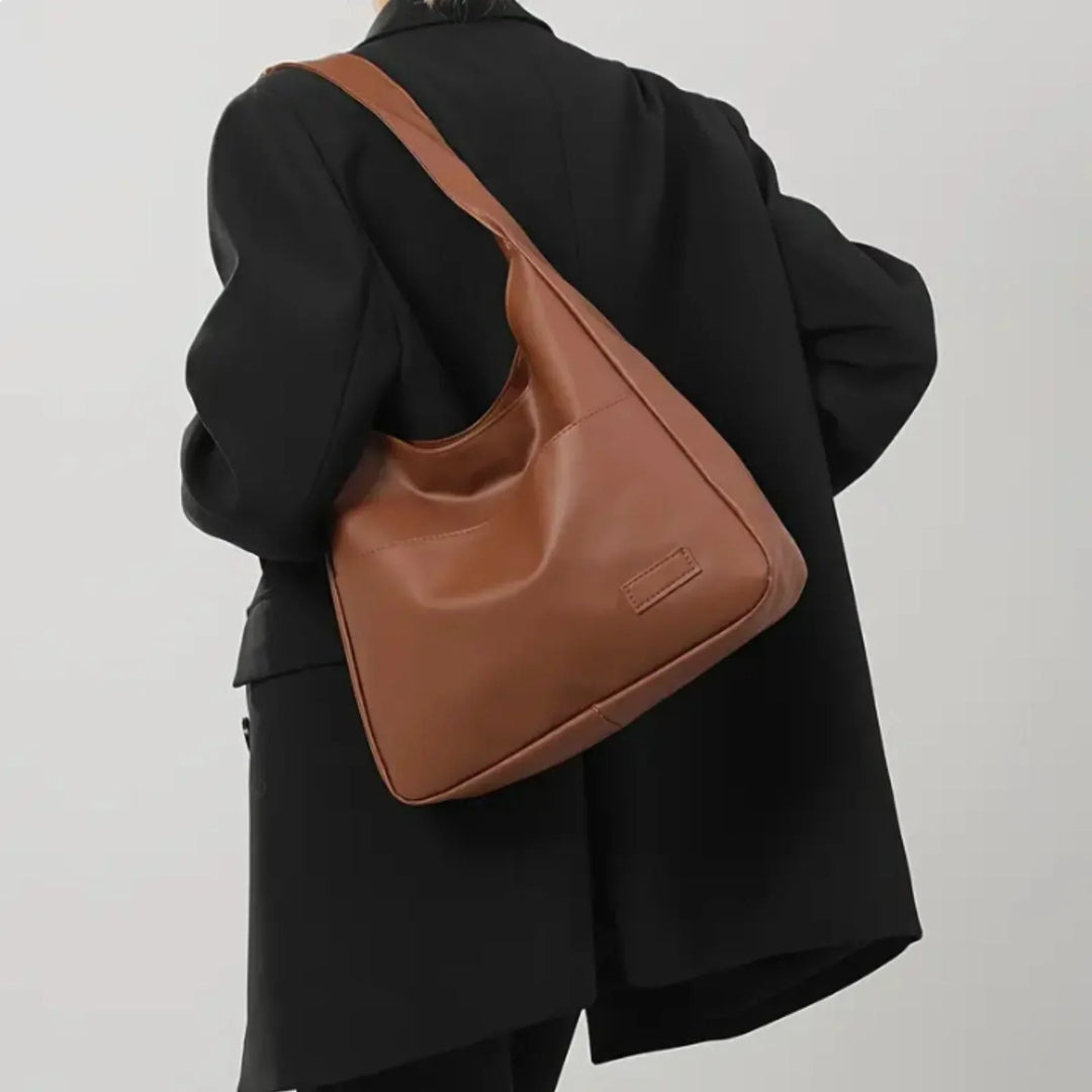 "Minimalistisk kunstlæder skuldertaske med justerbar rem, elegant design, perfekt til daglig brug eller events."