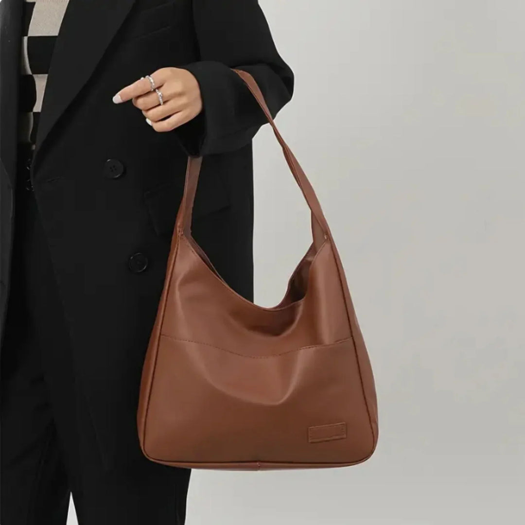 "Minimalistisk kunstlæder skuldertaske med justerbar rem, elegant design, perfekt til daglig brug eller events."