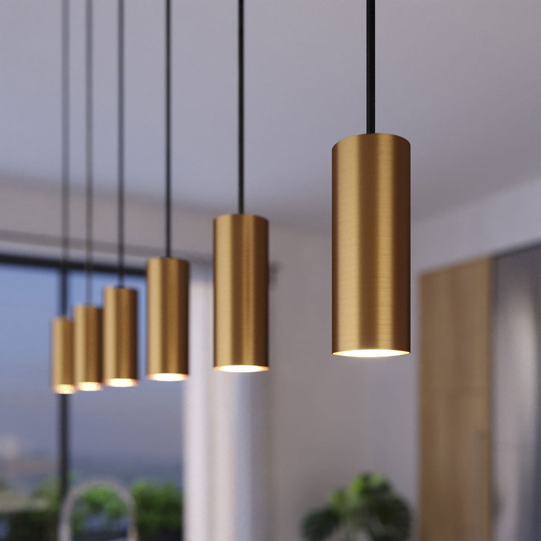 "Minimalistisk messing Tube pendel med børstet finish og justerbar sort stofledning, ideel til fokuseret lys over bordet."