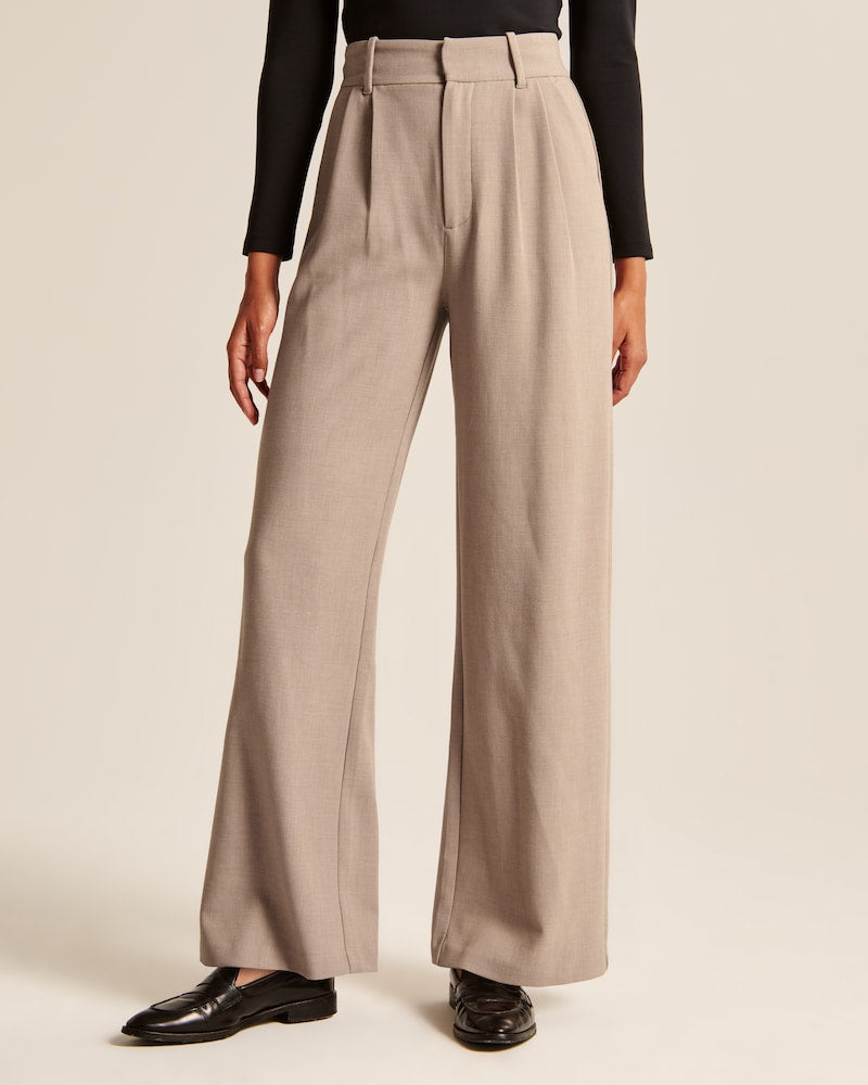 "Model iført beige polyester bukser med høj talje og bredde ben, ideel til professionelt og tidløst look."