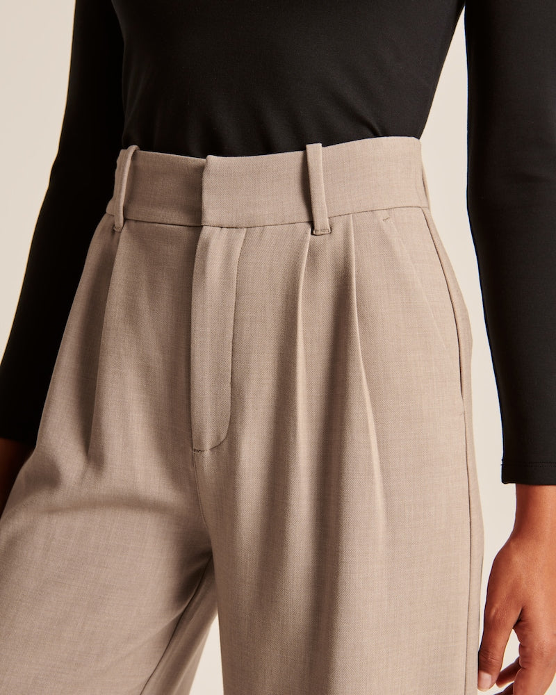 "Model iført beige polyester bukser med høj talje og bredde ben, ideel til professionelt og tidløst look."