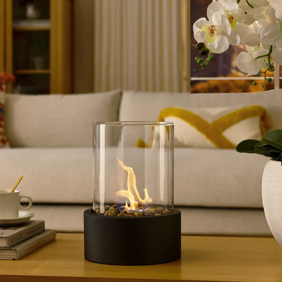"Moderne sort bærbar glaspejs med elegant design, sort base og gennemsigtigt glas, perfekt til indretning og varme."