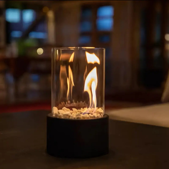 "Moderne sort bærbar glaspejs med elegant design, sort base og gennemsigtigt glas, perfekt til indretning og varme."