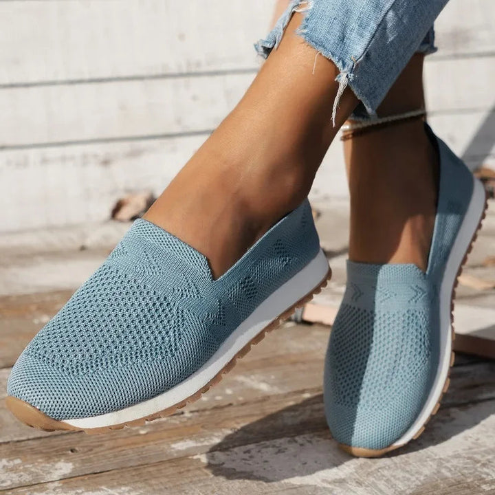 "Ortopædiske dame slip-ons i marineblå med åndbar fodseng, let slip-on design og elegant stil."