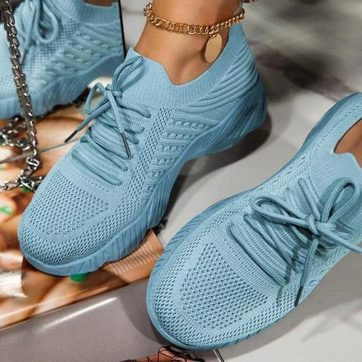 "Ortopædiske damesneakers i hvidt mesh med skridsikker gummisål, designet for komfort og støtte til daglig brug."