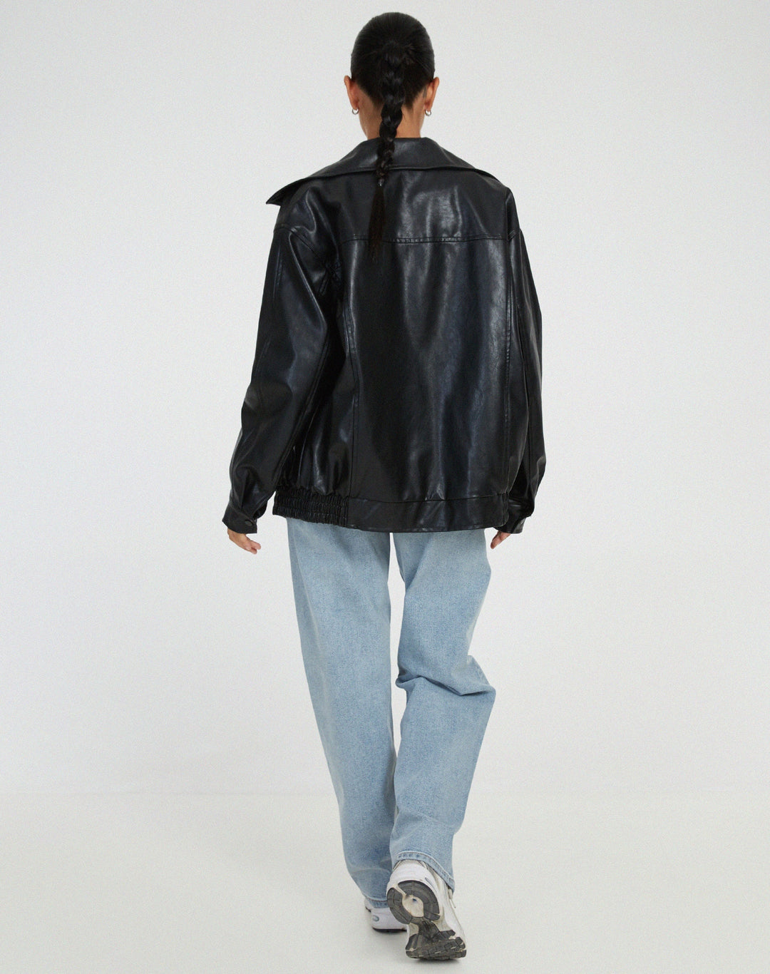 Kvinde iført oversized brun bomberjakke, viser den trendy urban streetstyle og komfort.