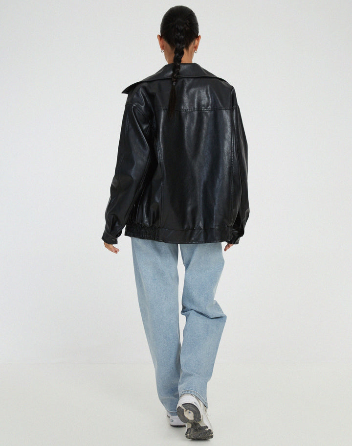 Kvinde iført oversized brun bomberjakke, viser den trendy urban streetstyle og komfort.