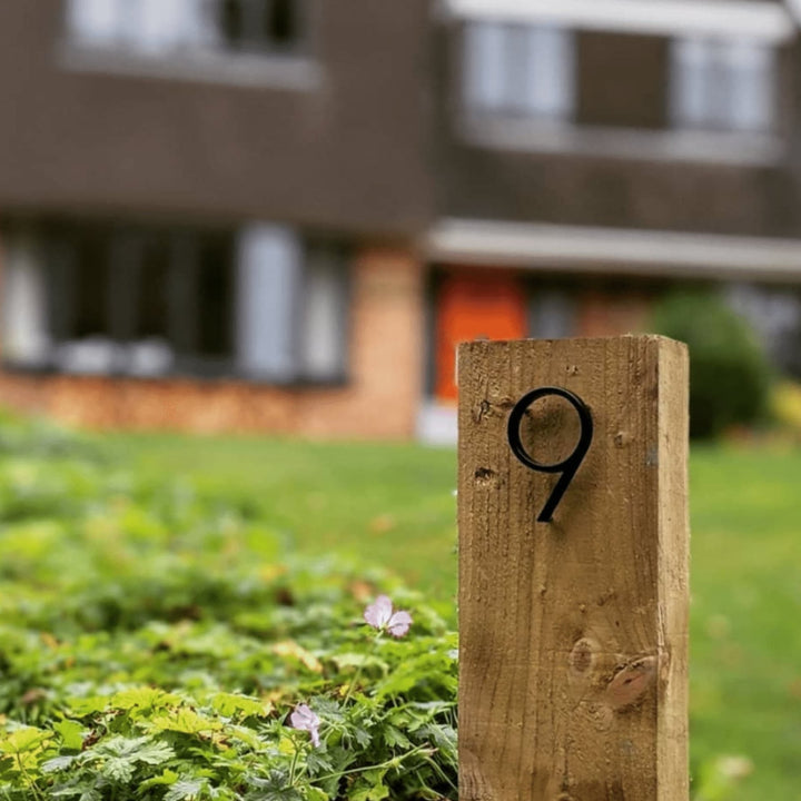 Nærbillede af stilfuldt sort husnummer '7' med moderne typografi. Perfekt til hjemmet.