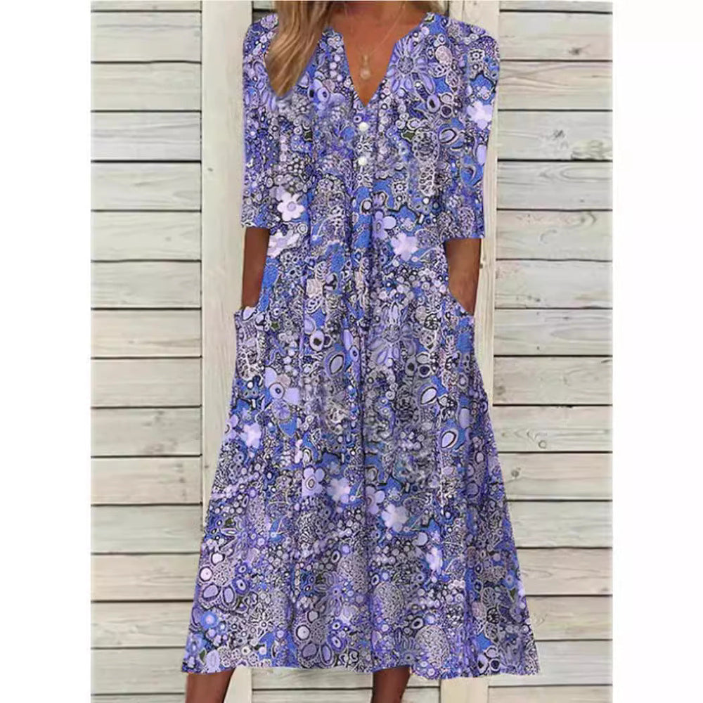 Nærbillede af den blomstrede skjortekjole, der viser de elegante knapdetaljer og det fine mønster.