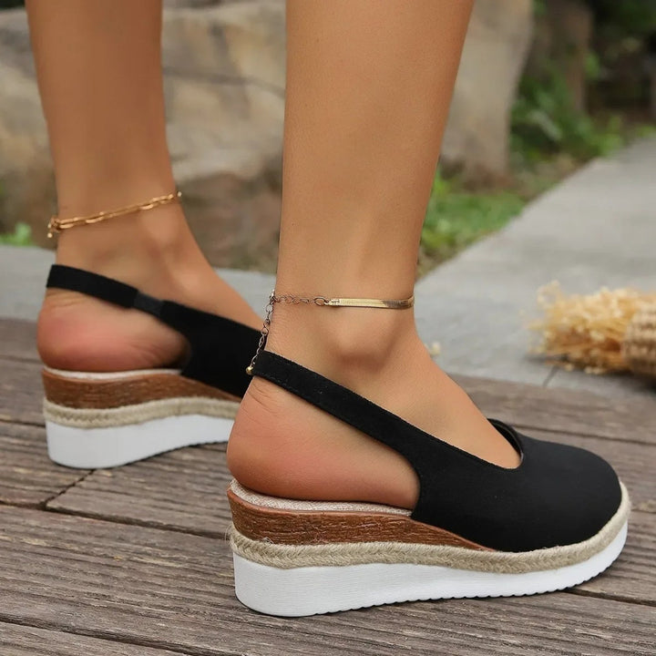 "Stilfulde kilehæl espadrillos i sort og brunt ruskind, med elegant design og komfortabel sål til kvinder."
