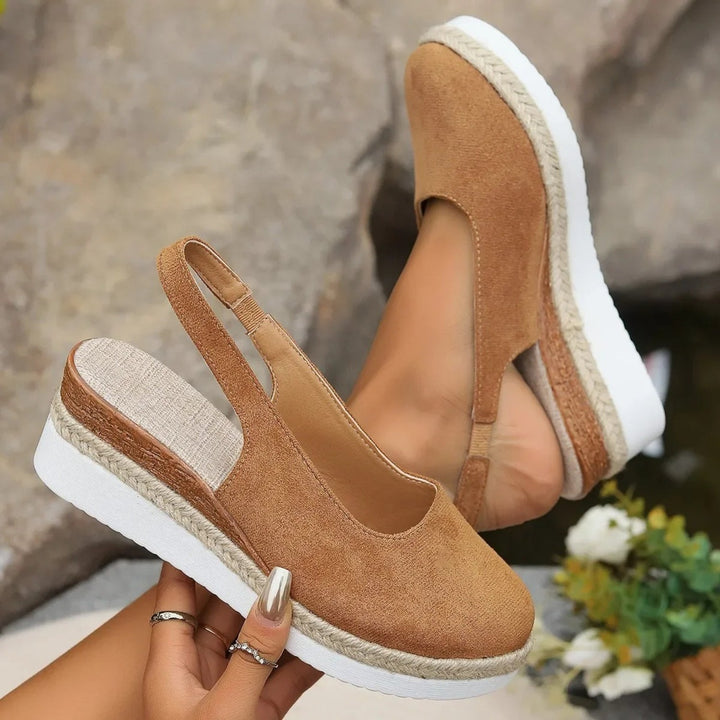 "Stilfulde kilehæl espadrillos i sort og brunt ruskind, med elegant design og komfortabel sål til kvinder."