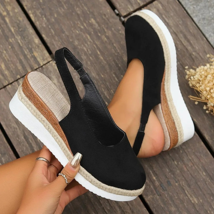 "Stilfulde kilehæl espadrillos i sort og brunt ruskind, med elegant design og komfortabel sål til kvinder."