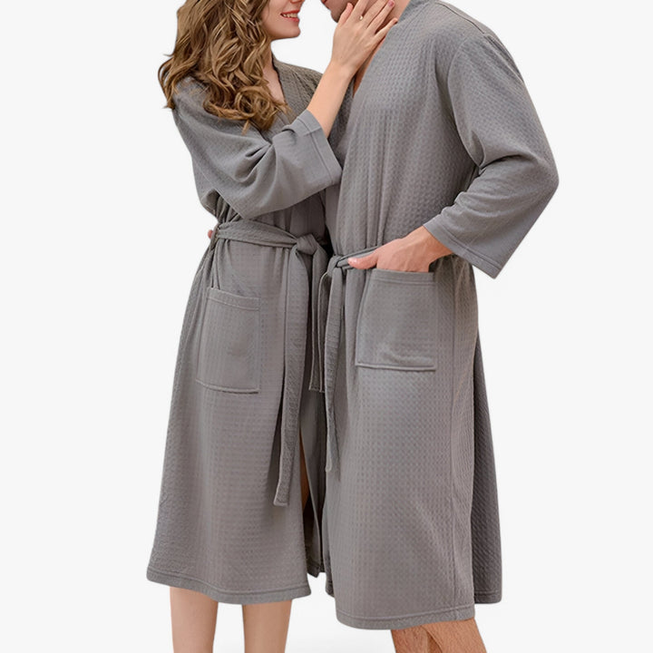Unisex badekåbe i en behagelig stil med V-hals, justerbart bælte og praktiske lommer, designet for optimal komfort og et stilfuldt udtryk.