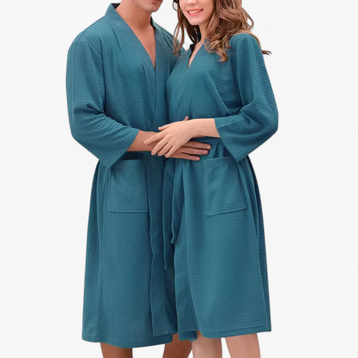 Unisex badekåbe i en behagelig stil med V-hals, justerbart bælte og praktiske lommer, designet for optimal komfort og et stilfuldt udtryk.