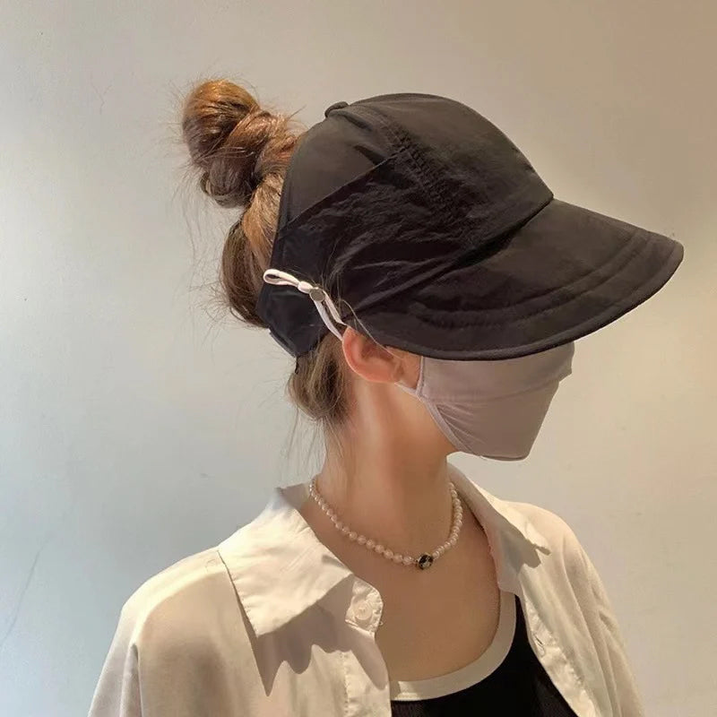 UV-beskyttende solhat til damer i åndbart materiale, åbent topdesign med bred skygge, justerbar for optimal pasform.